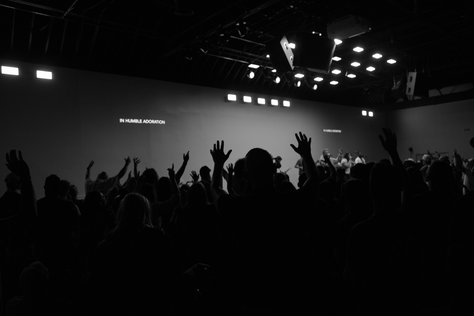 People raising their hands during worship at Mercy Road Church