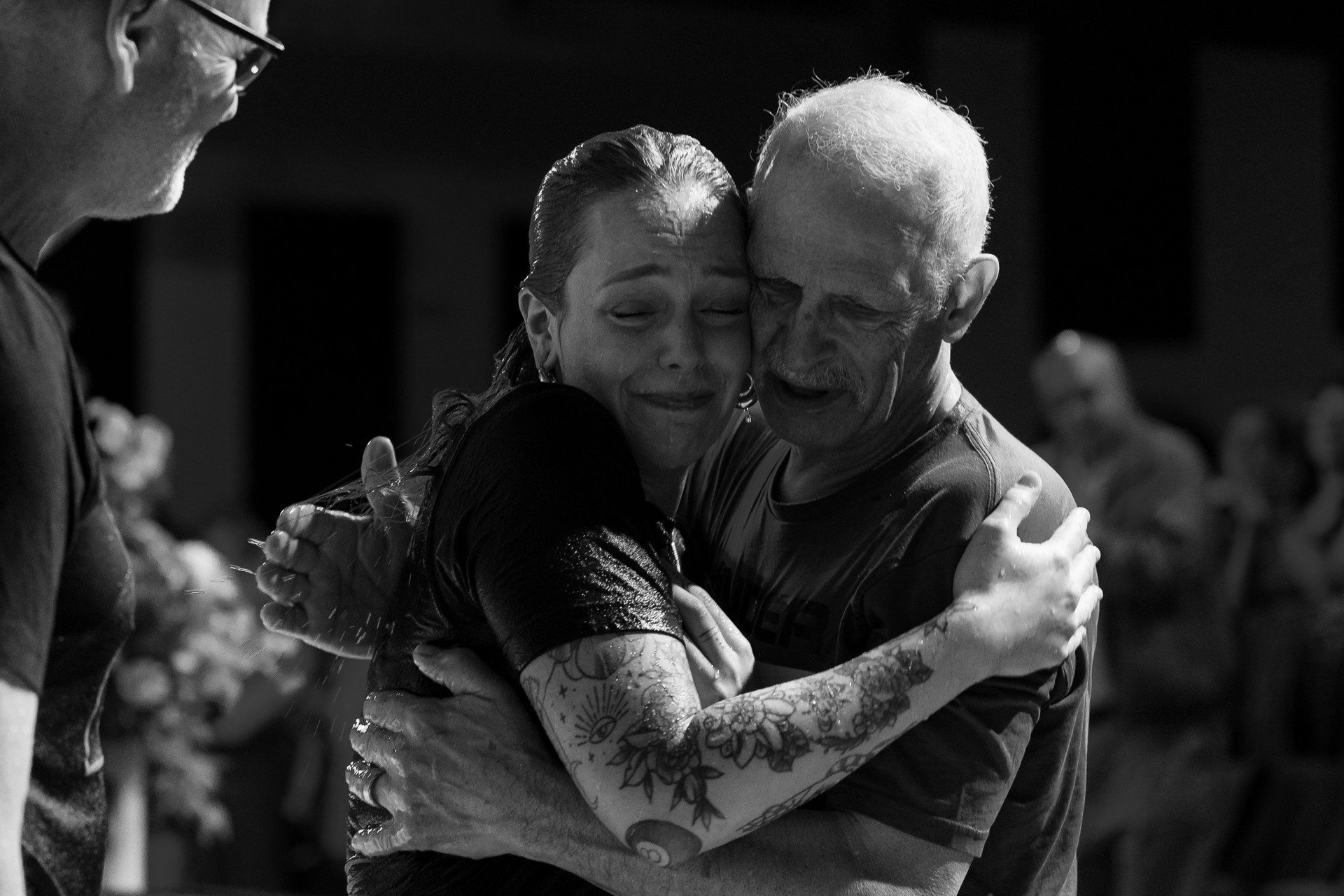A pastor embracing a participant at a baptism